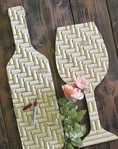 two vases made out of wine corks with flowers in the middle and a pen on top