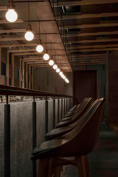 a row of bar stools sitting next to each other in front of a wall