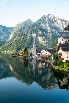 a lake with houses and mountains in the background