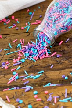 sprinkles are spilled out of a bottle onto a wooden table with paper towels