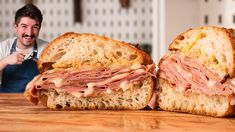 a man sitting in front of two halves of a sandwich