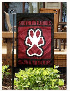 a red and black flag with the words southern illinois on it in front of some plants