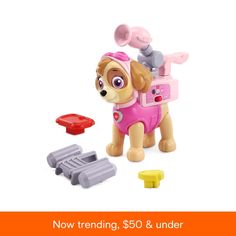 there is a toy dog with a pink shirt and purple pants next to other toys