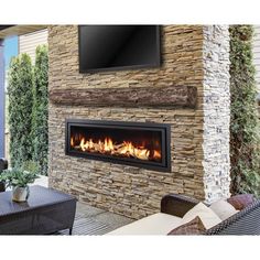 an outdoor fireplace with a flat screen tv mounted on it's wall above it