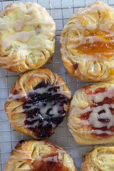 several pastries on a cooling rack with jam in the middle and jelly filling inside