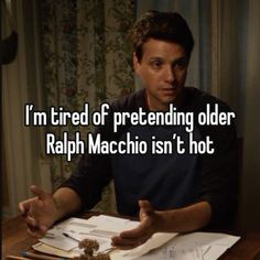 a man sitting at a table in front of a book with the caption i'm tired of pretending older rapp machio isn't hot