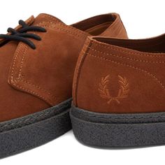 The Linden suede boot from Fred Perry elevates your everyday style with iconic British heritage. Crafted from supple suede with a chunky crepe sole that protects while lending a formal edge, these boots take you from tennis courts to the city streets in signature comfort and flair. Instantly make a statement with the classic tartan insole and embroidered laurel wreath on the heel pull honoring Fred Perry's stylish sport and streetwear roots beloved by underground subcultures worldwide. Fall Suede Sneakers With Leather Sole, Suede Sneakers With Textured Sole For Fall, Fall Suede Sneakers With Textured Sole, Suede Boots With Branded Insole For Streetwear, Sporty Low-top Suede Boots, Casual Suede Chukka Boots With Branded Insole, Classic Suede Boots For Streetwear, Vintage Suede Sneakers With Gum Sole, Suede Boots With Leather Sole For Streetwear