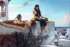 two women sitting on top of a building next to the ocean