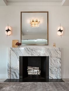 a fireplace with a mirror above it and some lights on the wall next to it