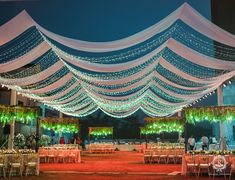 an outdoor wedding venue decorated with white and green lights