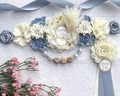 a bouquet of flowers on top of a table next to a ribbon and some ribbons