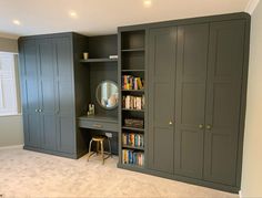 an empty room with bookshelves, cabinets and a mirror on the wall in it