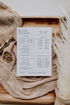 the wedding program is laid out on a wooden tray next to a pair of scissors