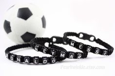 two black and white bracelets with the word neymor spelled in small letters next to a soccer ball