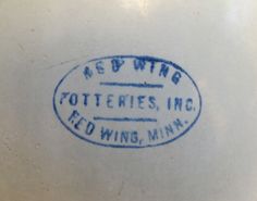 a white vase with blue writing on the bottom that says red wing potteries inc