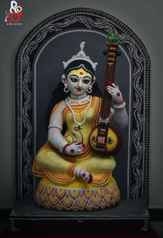 a statue with a guitar in it's hand and an ornate frame around it