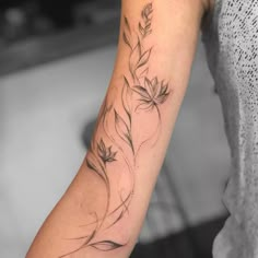 a woman's arm with a flower tattoo on the left side of her arm