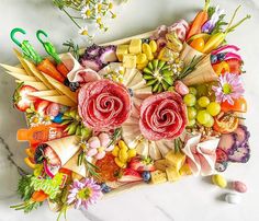 an arrangement of fruits and vegetables arranged in the shape of a heart on a marble surface