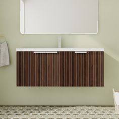 a bathroom vanity with a mirror above it and towel hanging on the wall next to it