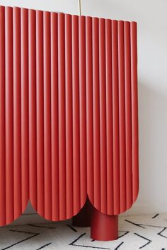 a red cabinet sitting on top of a white rug