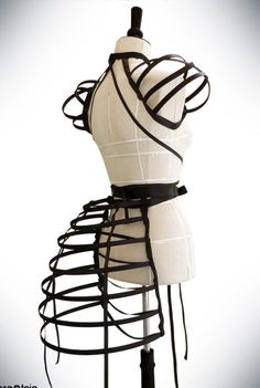 a white mannequin with black wire wrapped around it