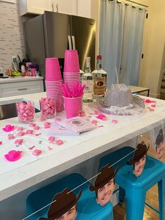 the table is set up with pink and blue decorations, including paper hats on them