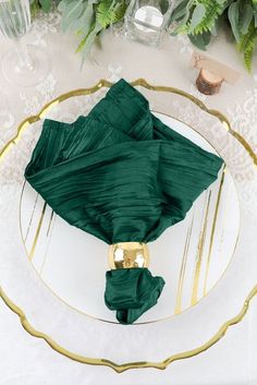 the table is set with green napkins and place settings for an elegant dinner party