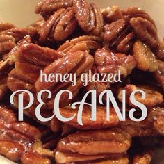 a pile of pecans in a white bowl with the words honey glazed pecans