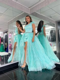 a woman in a blue dress is looking at herself in the mirror with her reflection