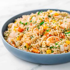 a blue bowl filled with rice and shrimp