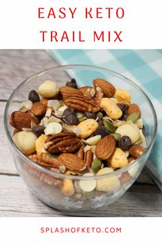 a glass bowl filled with trail mix on top of a wooden table