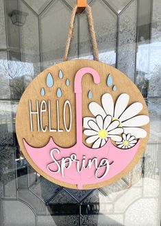 a wooden sign hanging from the side of a glass door that says hello spring on it