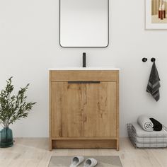 a bathroom vanity with a mirror above it and two shoes on the floor next to it