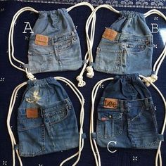 four denim drawstring bags sitting on top of a blue blanket