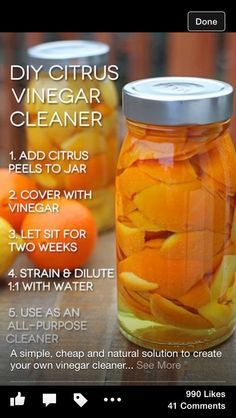 a jar filled with orange peels sitting on top of a wooden table next to other fruit