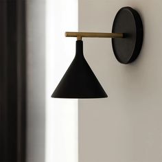 a black wall light hanging from the side of a white wall