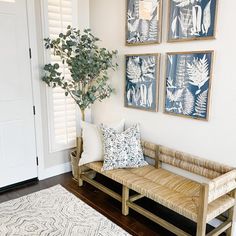 a living room filled with furniture and paintings on the wall next to a white door