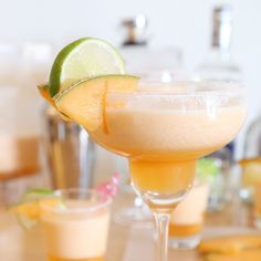 a close up of a drink in a glass on a table next to other glasses