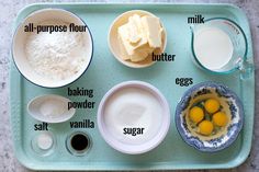 the ingredients to make an egg muffin are shown on a blue tray, including eggs, butter, sugar and milk