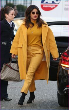 a woman in yellow is walking down the street