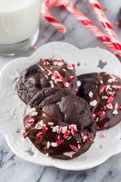 chocolate cookies with sprinkles on a plate next to a glass of milk