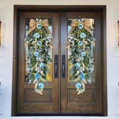 the front door is decorated with blue flowers and greenery