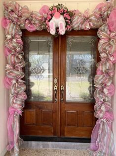 the front door is decorated with pink and silver ribbons