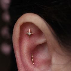 a woman's ear with a single star piercing