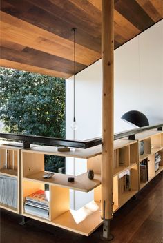 an open book shelf in the middle of a room with wooden floors and ceilinging