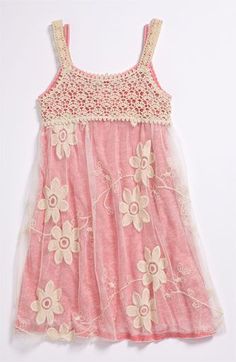 a pink dress with white flowers on the front and beige trimmings, hanging from a hanger