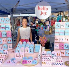 a woman standing in front of a table with lots of cards and magnets on it