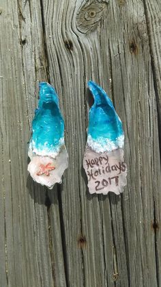 two blue and white rocks sitting on top of a wooden table next to each other