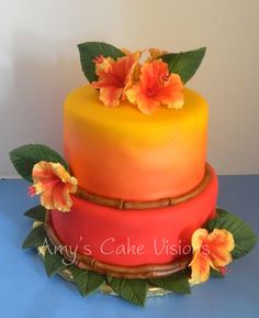 a three layer cake with orange and yellow frosting, flowers on the top tier