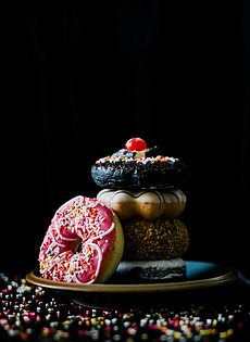 three donuts stacked on top of each other with sprinkles around them